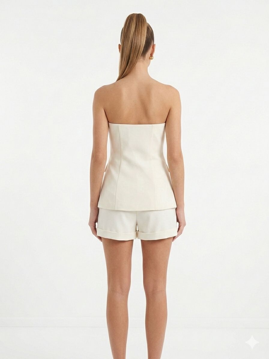 Corsetto con bottoni dorati e shorts con risvolto.